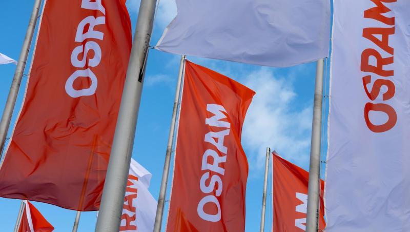 Flaggen mit dem Logo von Osram wehen im Wind.