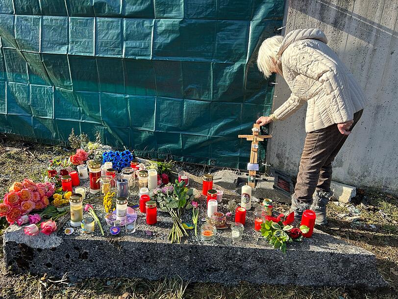 Rentnerin Gudula stellt am Sonntag ein Holzkreuz auf, das ein Vorschulkind vor 25 Jahren gebastelt hatte.
