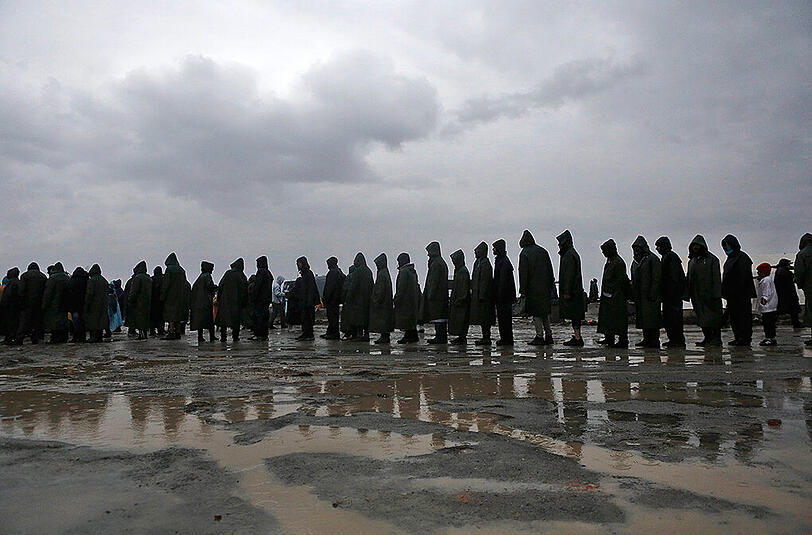 Hunderte Flüchtlinge aus dem Lager in Idomeni durchqueren einen reißenden Fluss auf griechischer Seite, um illegal nach Mazedonien zu gelangen.