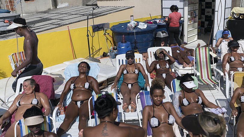 Frauen sonnen sich auf einer Dachterrasse in Rio de Janeiro. Sie tragen Bikinis aus Klebestreifen, dies soll besonders weiße Bräunungsstreifen fördern.