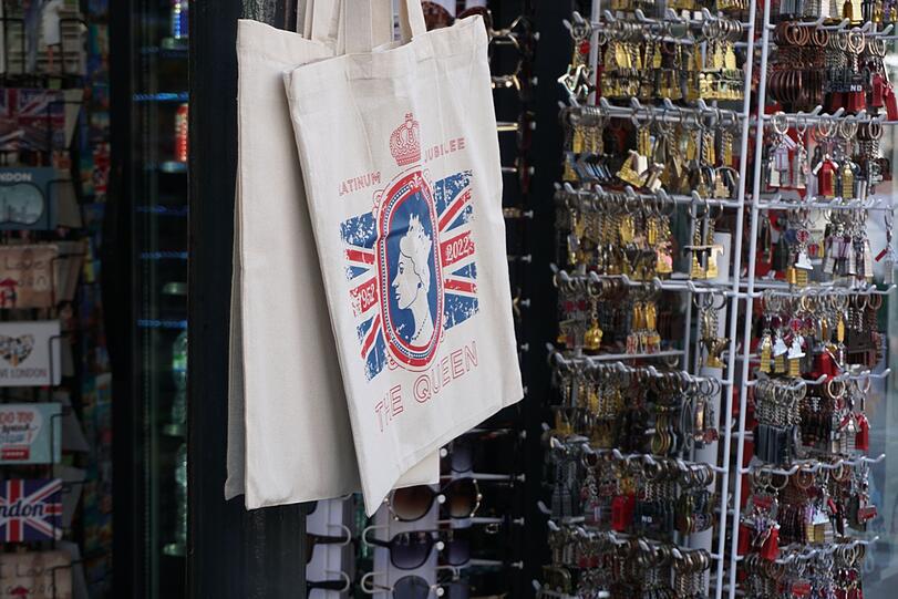 In einem Souvenirgeschäft hängen Stoffbeutel mit dem Porträt der Queen.