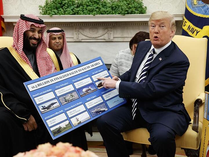 US-Präsident Donald Trump (r) empfängt den saudischen Kronprinzen Mohammed bin Salman 2018 im Weißen Haus und zeigt dabei auf ein Plakat, auf dem die Waffenverkäufe von den USA an Saudi-Arabien detailliert erklärt sind.
