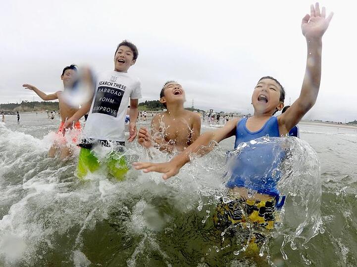 Kinder spielen im Wasser: Nach der Nuklearkatastrophe von Fukushima wurde der Strand zum ersten Mal wieder für Besucher zugelassen.