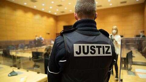 Ein Justizbeamter steht in einem Gerichtssaal.