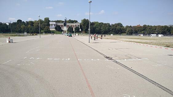 Auf der Theresienwiese ist es bisher noch ruhig. "Ihr seid nicht das Volk" steht mit Kreide auf dem Boden geschrieben.