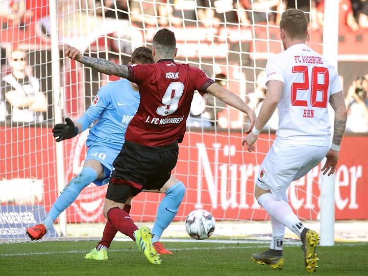 Der Nürnberger Mikael Ishak (M) erzielt trotz der Augsburger Gregor Kobel (l) und Andre Hahn den Treffer zum 1:0.