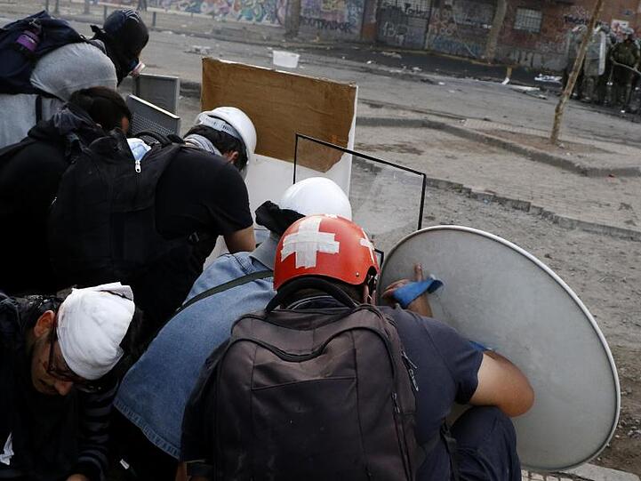 Demonstranten und Polizisten stehen sich von einer Straßenseite zur anderen gegenüber.