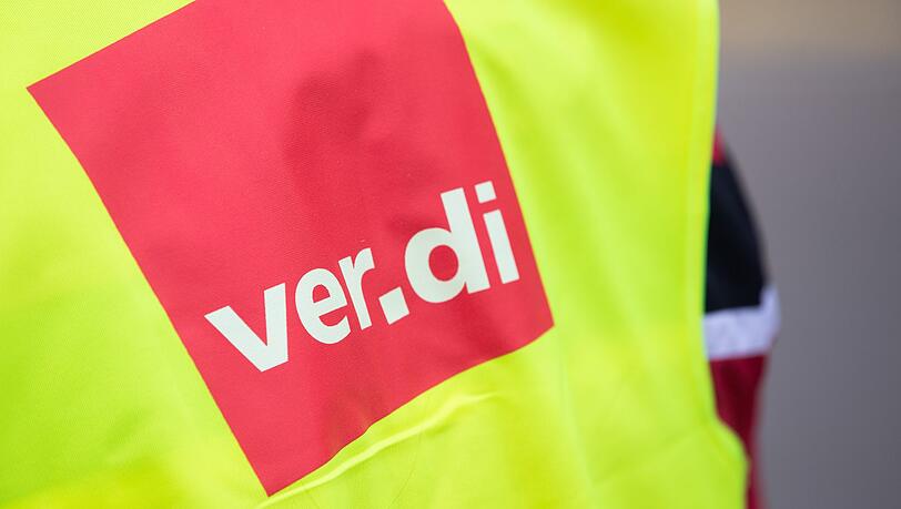 Ein Beschäftigter trägt bei einem Warnstreik eine Warnweste von Verdi.