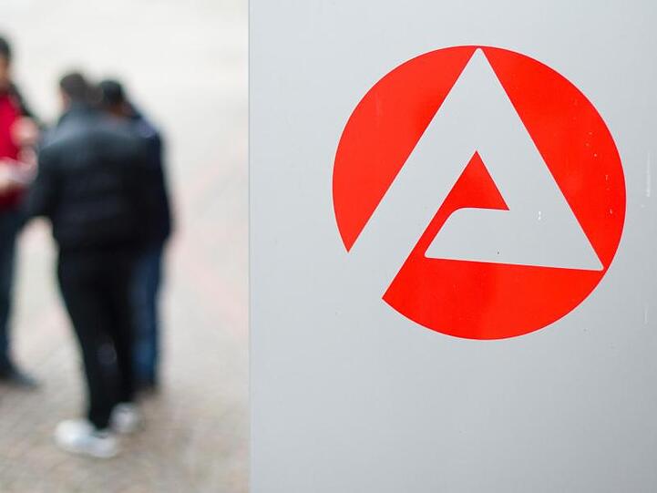 Männer stehen vor der Bundesagentur für Arbeit.