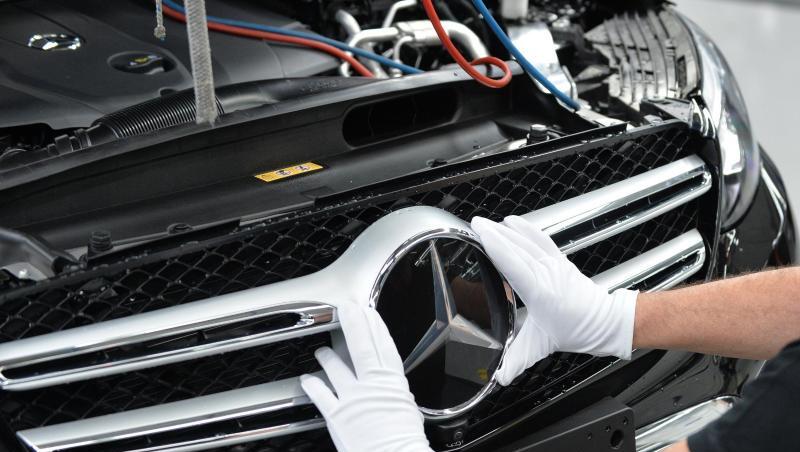 Ein Mitarbeiter von Mercedes-Benz bringt den Stern an einem Auto der C-Klasse an. Ein Mitarbeiter von Mercedes-Benz bringt den Stern an einem Auto der C-Klasse an.