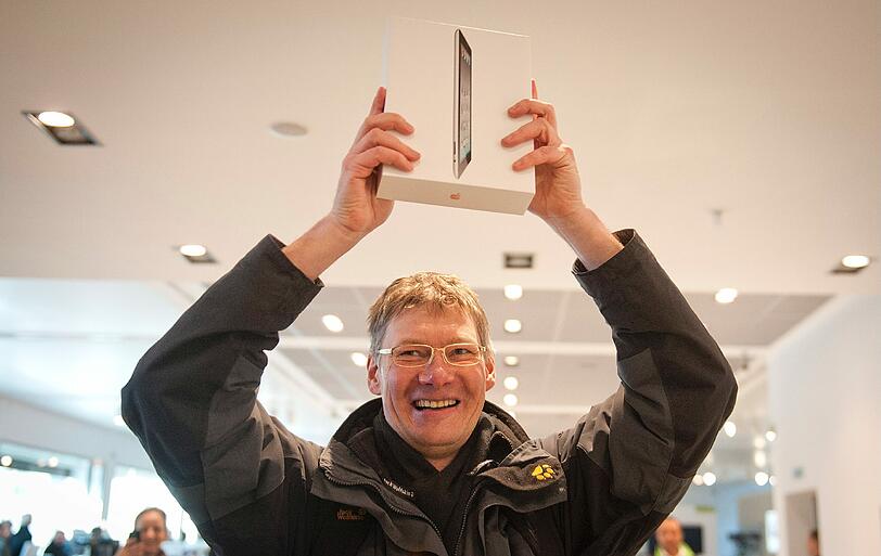 Dieser Herr freut sich, denn das Warten hat sich für ihn gelohnt: Stolz hält er hält das sehnsüchtig erwartete Tablet in die Höhe.