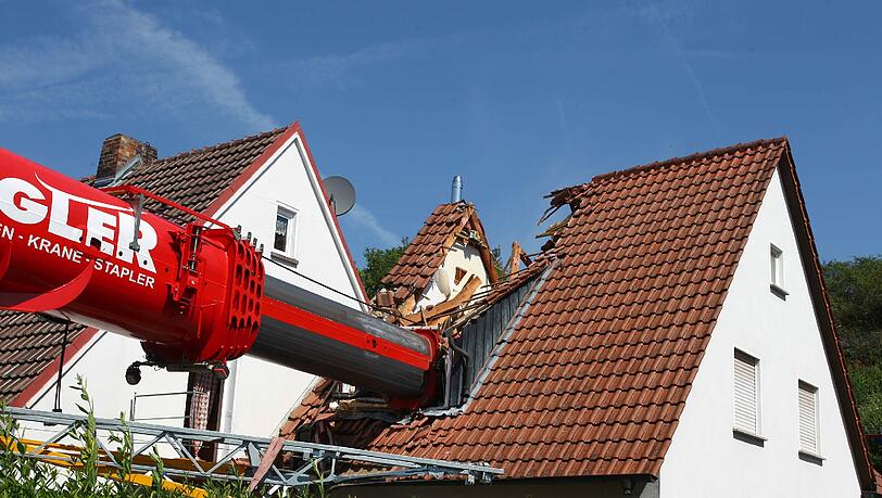 Eine Aktion, die schief ging: Als Bauarbeiter einen Kran über einen Mauer heben wollten, kippte das Fahrzeug um. Eine Aktion, die schief ging: Als Bauarbeiter einen Kran über einen Mauer heben wollten, kippte das Fahrzeug um.