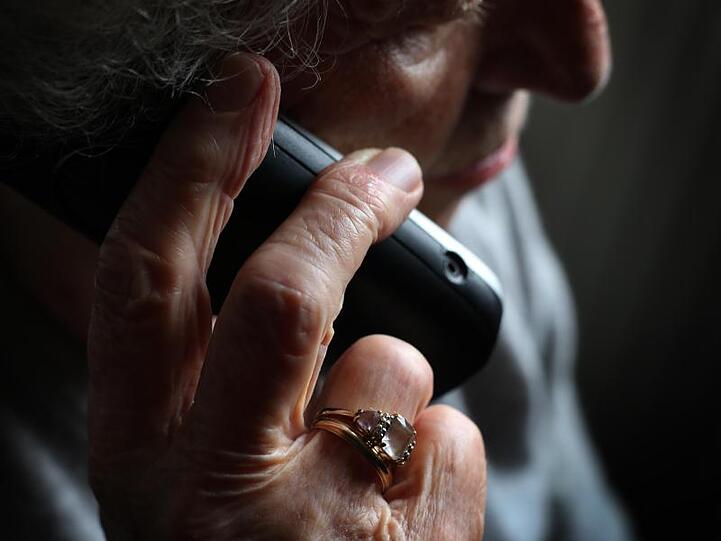 Eine ältere Frau telefoniert mit einem schnurlosen Festnetztelefon. Foto: Karl-Josef Hildenbrand/dpa/Illustration
