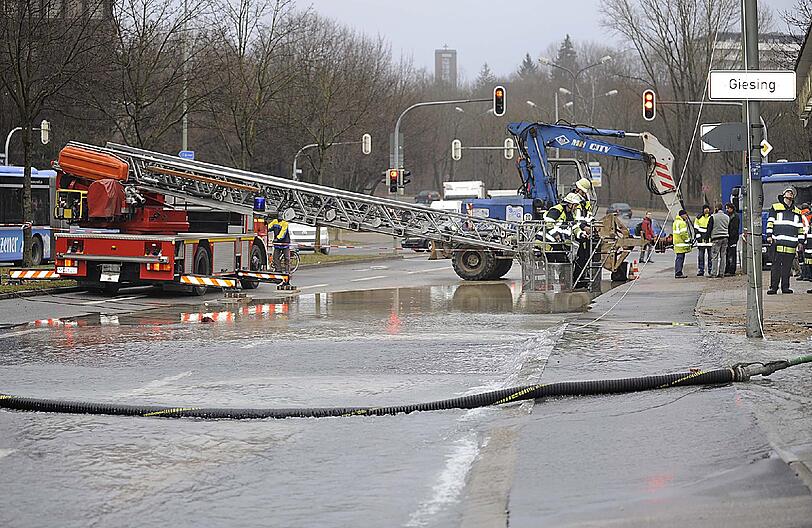 Candidstraße:
Der Bruch einer 400 mm starken Wasserleitung setzt in den frühen Morgenstunden die Candidstraße auf einer Länge von 300 Meter unter Wasser. Angrenzende Keller laufen voll Wasser und müssen ausgepumpt werden. Wegen akuter Umsturzgefahr wird ein Beleuchtungsmast durch die Feuerwehr umgeschnitten.