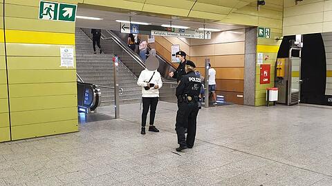 Erwischt! Ein Mann ohne Maske wird am Stachus kontrolliert.