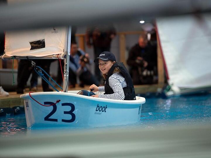 Eines der etwas kleineren Modelle: Model Mia in einem "Optimist" bei der Wassersportmesse "Boot 2020".
