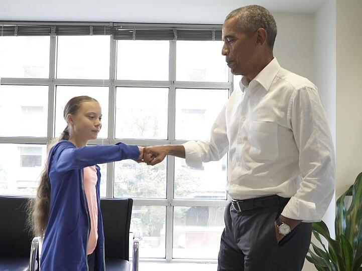 Greta Thunberg wird von Barack Obama per "Fist Bump" verabschiedet.