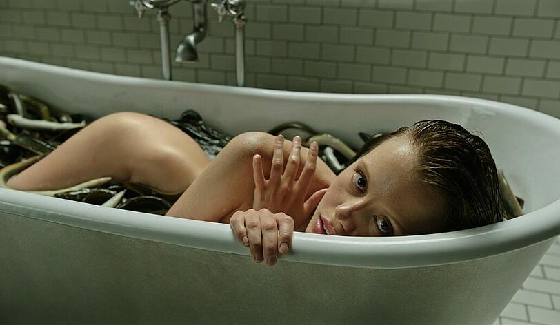 Die mysteriöse Hannah (Mia Goth) badet mit Aalen.