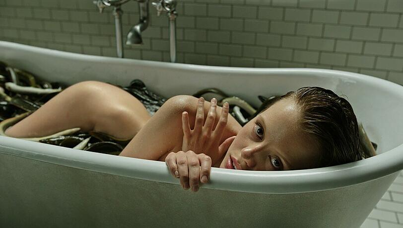 Die mysteriöse Hannah (Mia Goth) badet mit Aalen.