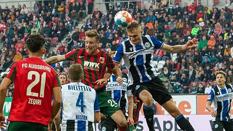 Augsburgs Andre Hahn (hinten, l) und Bielefelds Amos Pieper im Kopfballduell.