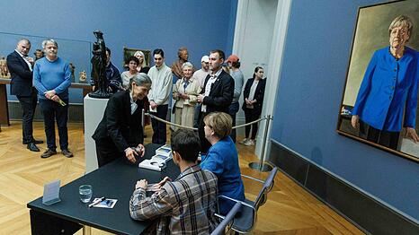 Im Bode-Museum signierte Merkel am Nachmittag Kunstpostkarten gemeinsam mit dem Maler ihres Portr&auml;ts.