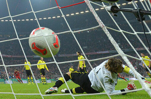Torwart Roman Weidenfeller von Dortmund lässt den Ball zum 1:0 durch Bayerns Arjen Robben (5.v.l.) in Tor.