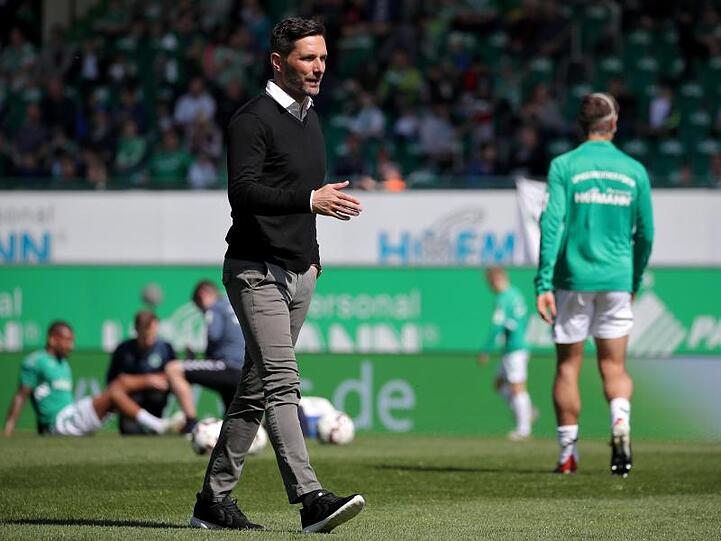 Trainer Stefan Leitl geht vor Spielbeginn übe den Rasen. Foto: Daniel Karmann/Archivbild