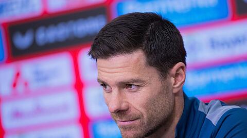 Bayer Leverkusens Trainer Xabi Alonso sitzt in einer Pressekonferenz.