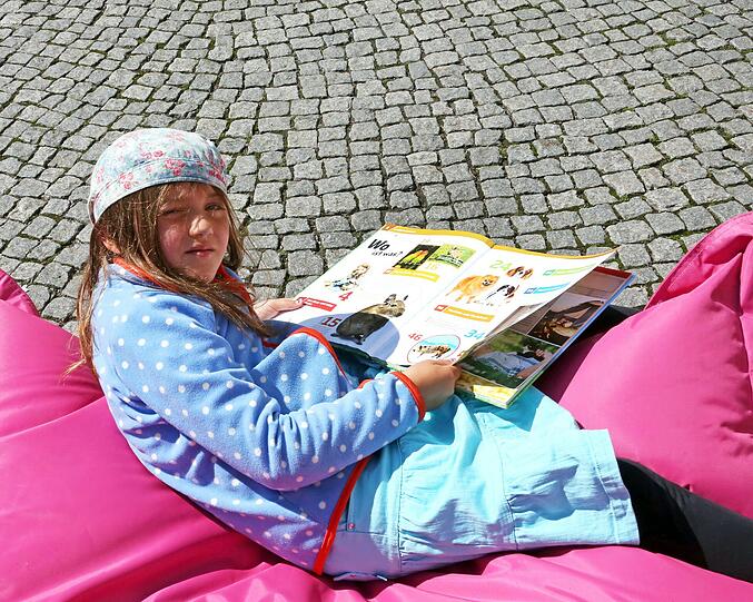 Die sechsjährige Paula schmökert im Buch &bdquo;Haustiere&ldquo;.