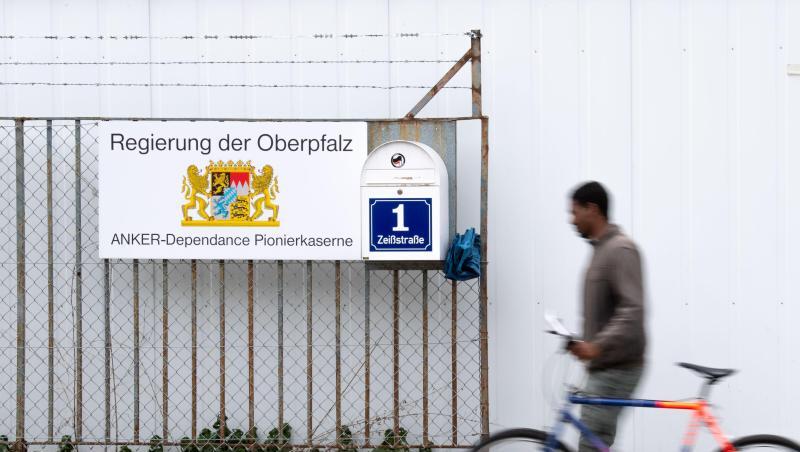 Ein Mann mit einem Fahrrad geht an einem Ankerzentrum. Foto: Lino Mirgeler/Archivbild Ein Mann mit einem Fahrrad geht an einem Ankerzentrum. Foto: Lino Mirgeler/Archivbild