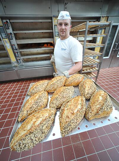 Schritt 6:Die Brote werden in drei Öfen auf Steinplatten gebacken. Ein zwei Kilo schwerer Roggenlaib ist zwei Stunden bei über 200 Grad im Ofen. &bdquo;Es braucht Zeit, bis die Wärme ins Brot dringt&ldquo;, sagt Magnus Müller-Rischart. Fünf weitere Öfen sind das so genannte &bdquo;Semmelkarussell&ldquo;, in die komplette Chargen geschoben werden. So muss der Bäcker nicht jede Semmel einzelnd in die Hand nehmen.