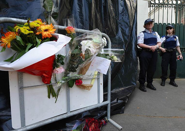 Die Menschen legen Blumen vor dem Haus der getöteten Frau und Kinder in Nantes ab.