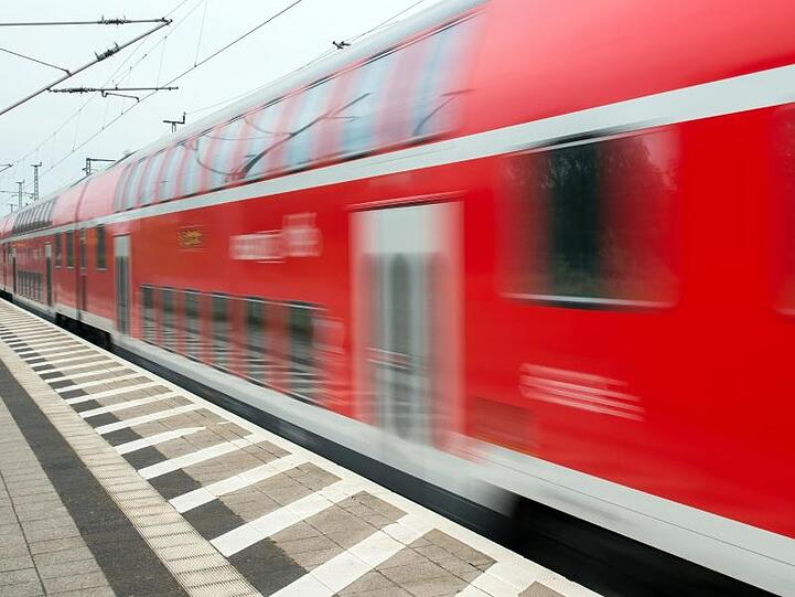 Ein Regionalexpress der Deutschen Bahn fährt an einem Bahnhof vorbei. Foto: Patrick Pleul/Archivbild