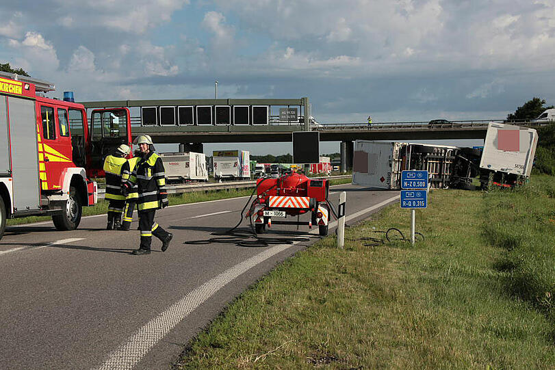 Vermutlich weil er zu schnell auf die Autobahn fährt, kommt ein Laster in der Kurve von der Fahrbahn ab und fährt in die Leitplanke. Sein Hänger kippt um.