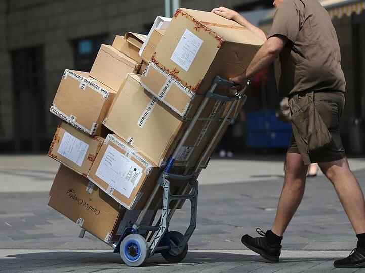 Ein Paketbote liefert Pakete aus. Foto: Oliver Berg/Archivbild
