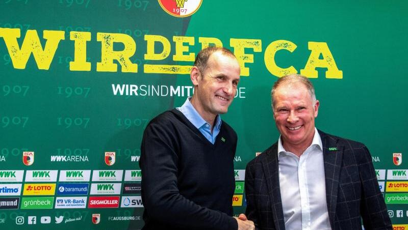 Sportdirektor Stefan Reuter (r) und Heiko Herrlich geben sich bei einer Pressekonferenz die Hände. Foto: Stefan Puchner/dpa/Archivbild
