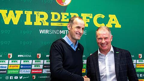 Sportdirektor Stefan Reuter (r) und Heiko Herrlich geben sich bei einer Pressekonferenz die Hände. Foto: Stefan Puchner/dpa/Archivbild