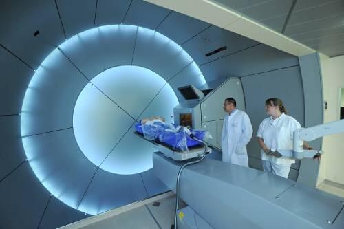 Der Therapieplatz &ndash; Durchmesser 11 Meter: In der &bdquo;Gantry&ldquo; wird der Tumor des Patienten punktgenau mit Protonen beschossen und zerstört. Rechts: Professor Manfred Herbst und Jutta Schreiber positionieren die Patientenliege.