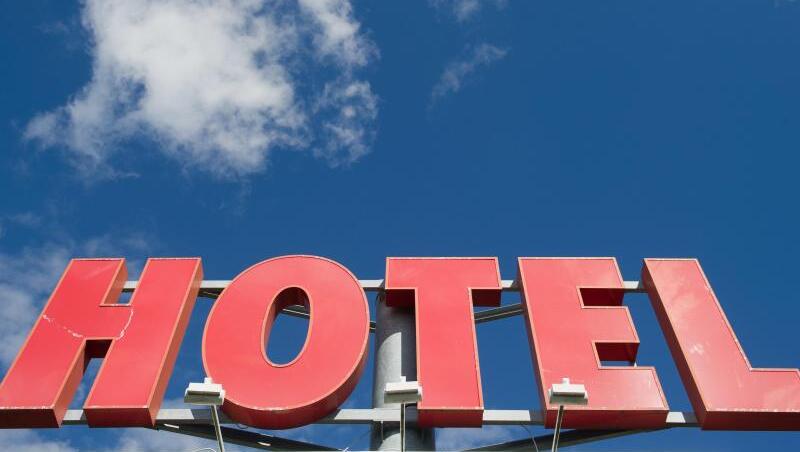 Der Schriftzug "Hotel" vor blauem Himmel. Bayern hat ein Beherbergungsverbot für Urlauber aus inländischen Corona-Risikogebieten beschlossen.
