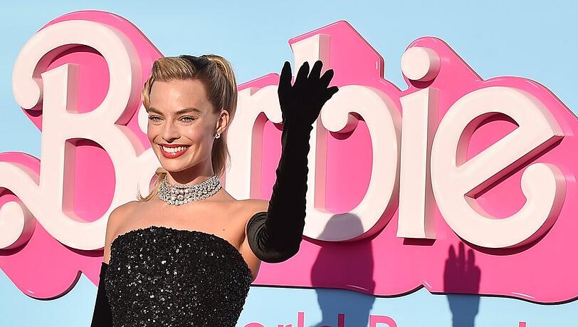 Margot Robbie winkt bei der Weltpremiere von "Barbie" ins Publikum.