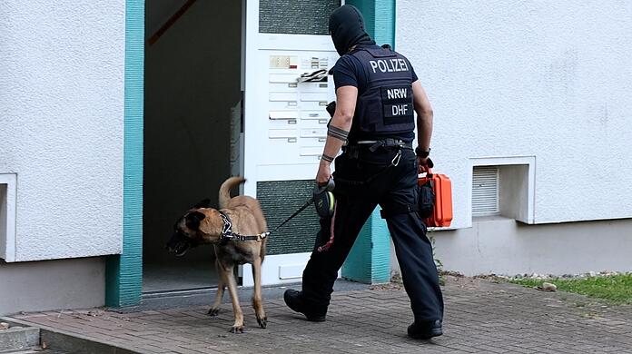 Ein Polizist und ein Spürhund betreten während eines SEK-Einsatzes ein Wohnhaus. (Symbolbild)