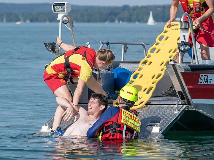 DLRG-Mitglieder nehmen auf einem See mit einem Boot an einer Übung teil. Foto: Peter Kneffel/dpa/Archivbild
