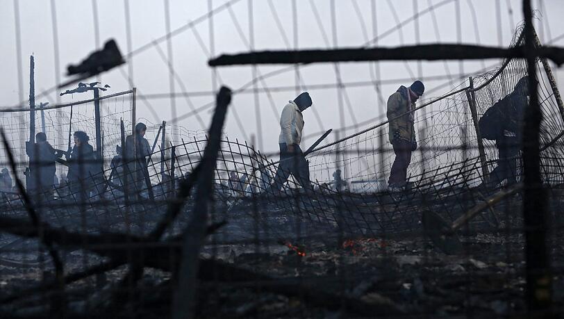 Das von einem Brand teilweise zerstörtes illegales Flüchtlingscamp im französischen Calais. Lastwagenfahrer und Landwirte fordern seit langem die Räumung des wilden Flüchtlingscamps. Foto: Thibault Vandermersch Das von einem Brand teilweise zerstörtes illegales Flüchtlingscamp im französischen Calais. Lastwagenfahrer und Landwirte fordern seit langem die Räumung des wilden Flüchtlingscamps. Foto: Thibault Vandermersch