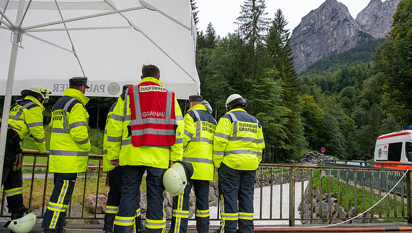 Einsatzkräfte der Feuerwehr stehen nach einer Flutwelle in der Höllentalklamm bereit, um im Notfall Opfer aus dem Fluss Hammersbach zu bergen.