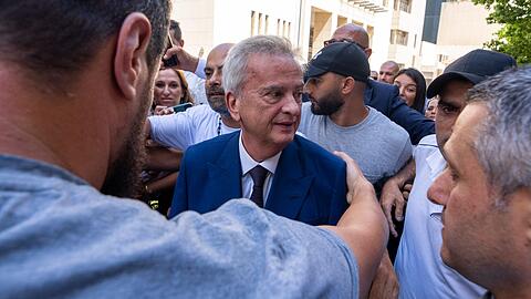 Riad Salameh (M), scheidender libanesische Zentralbankchef, grüßt Mitarbeiter, während er von Leibwächtern bei einer Abschiedszeremonie zum Ende seiner 30-jährigen Amtszeit vor dem Gebäude der Zentralbank begleitet wird.