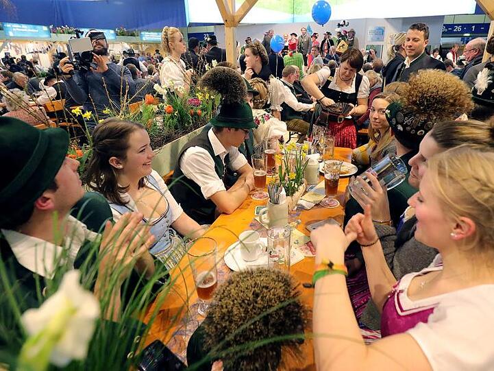 Fröhlich verfolgen Gäste der Bayern-Halle auf der Internationalen Grünen Woche in Berlin beim Ländertag Bayerns die kulturellen Darbietungen.