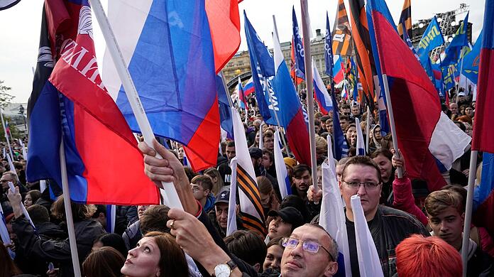 Demonstranten halten russische Fahnen zur Unterstützung der Scheinreferenden auf dem Manezhnaya-Platz in Moskau.