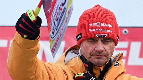 Skisprung-Bundestrainer Stefan Horngacher hält die Fahne hoch.