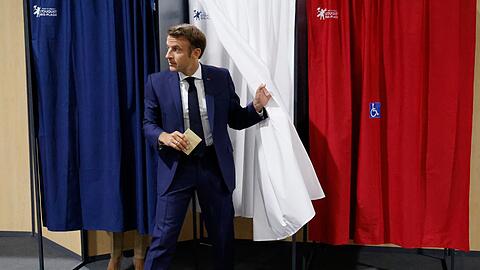 Emmanuel Macron, Präsident von Frankreich, verlässt die Wahlkabine, bevor er seine Stimme in der ersten Runde der französischen Parlamentswahl abgibt.