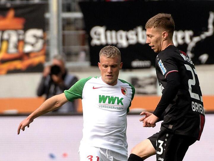 Augsburgs Philipp Max und Leverkusens Mitchell Weiser (l-r.) bemühen sich um den Ball. Foto: Stefan Puchner